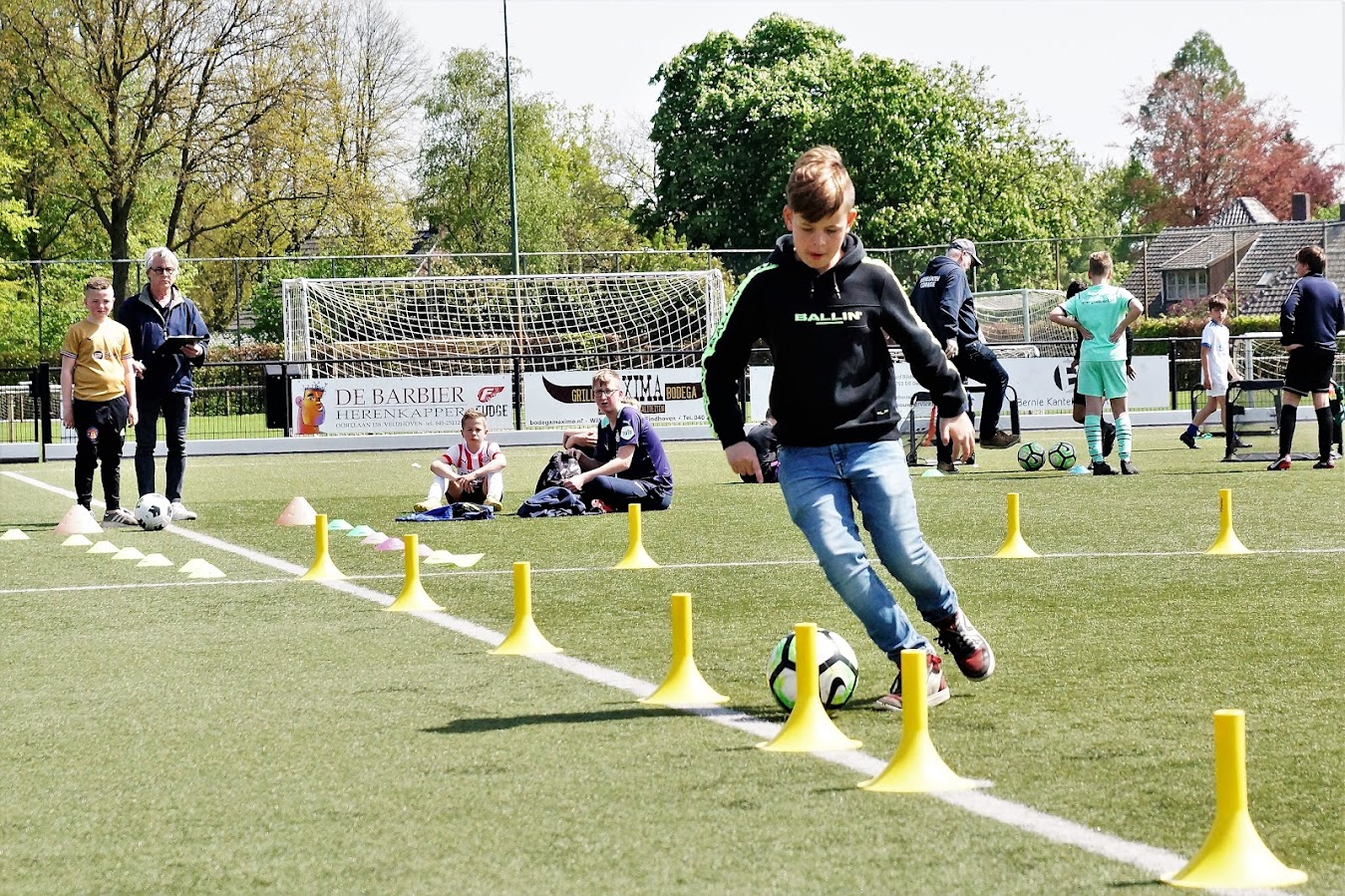 Jongen dribbelt tussen pionnen tijdens Skillgame standaard event