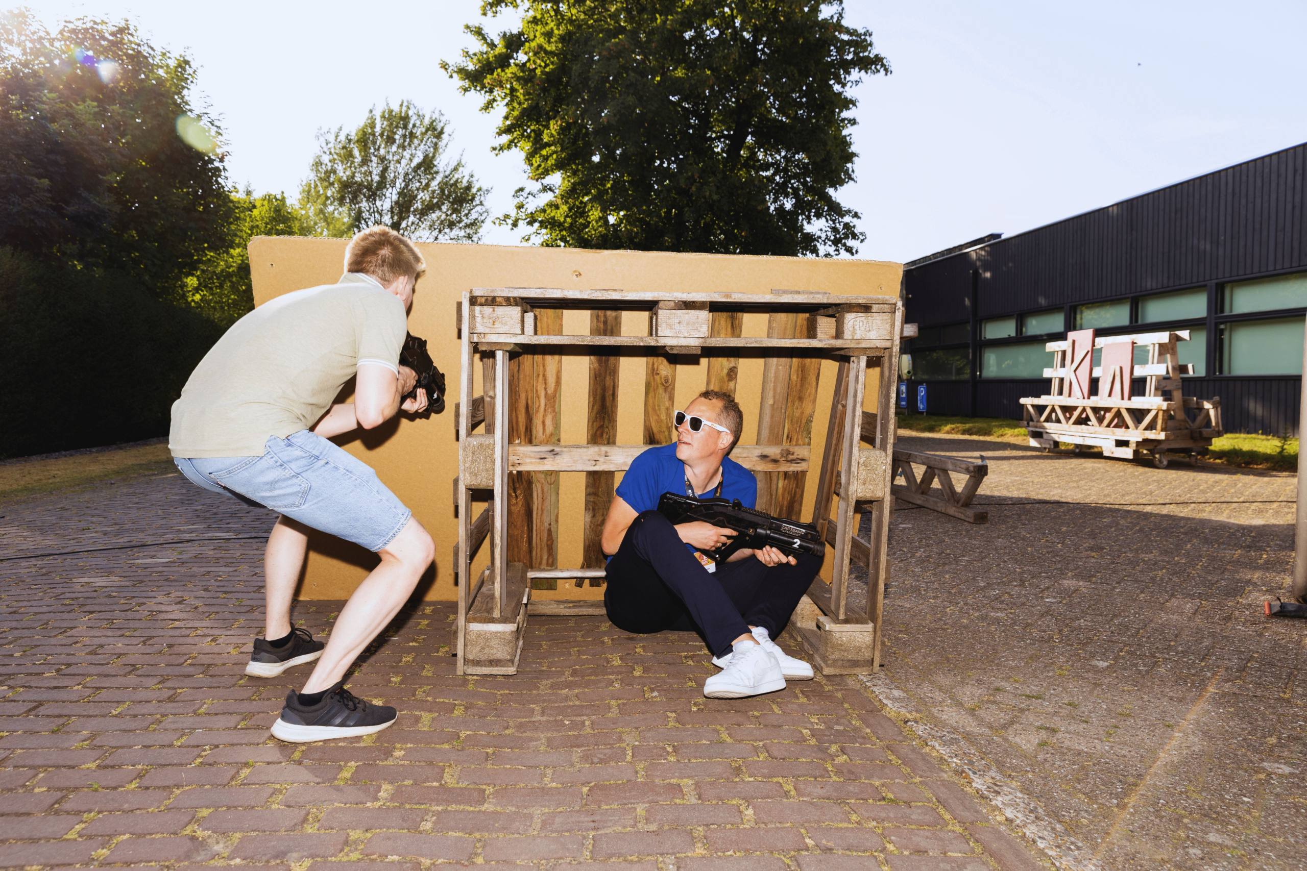 Lasergamen YourHosting man zoekt dekking in een pallet