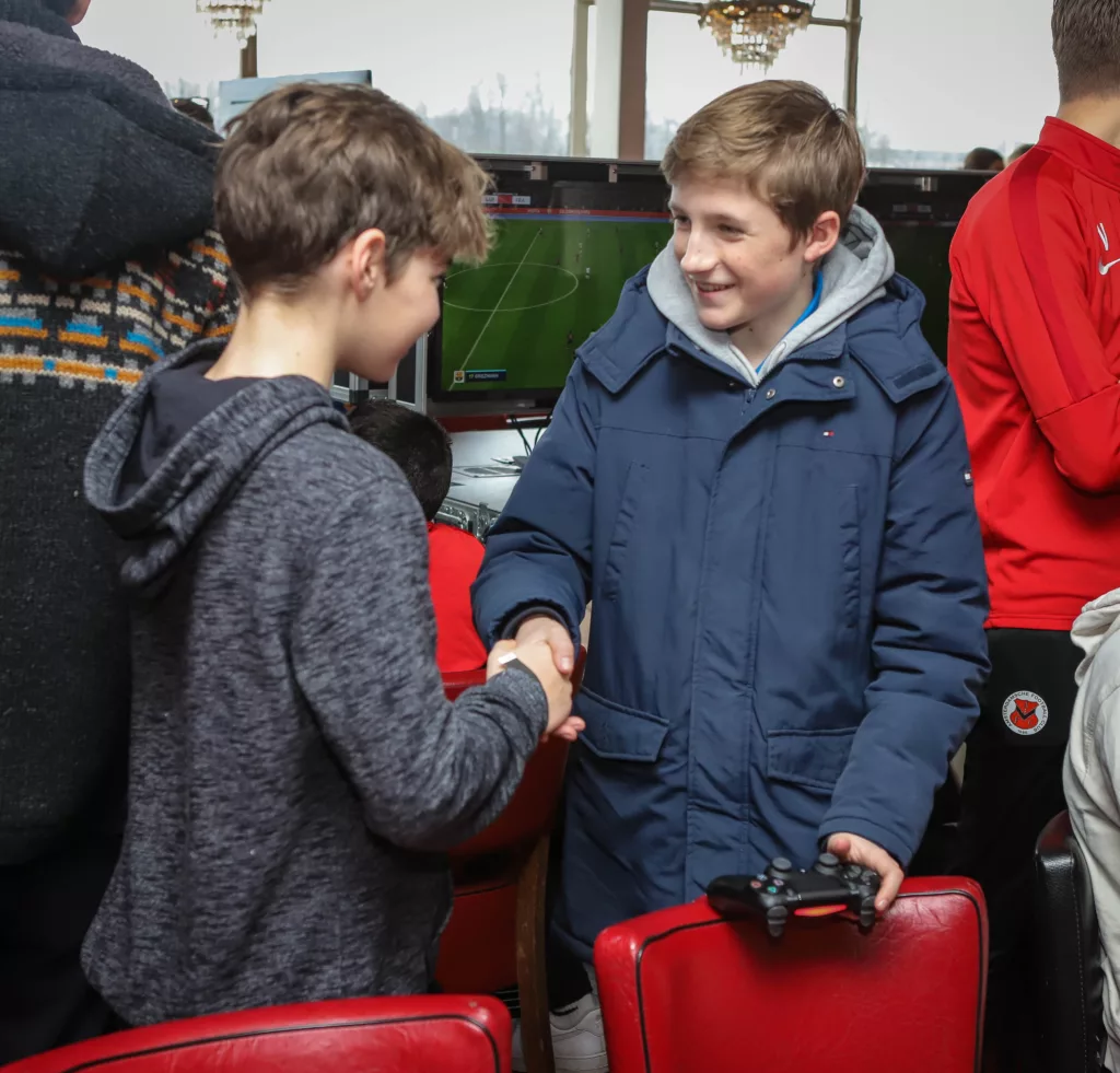 Deelnemers van een FIFA toernooi schudden handen