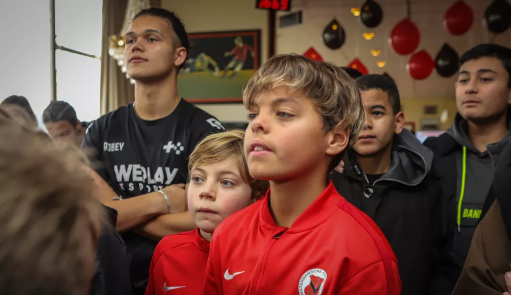 Jongen en eventmanager kijken naar deelnemers van een FIFA toernooi