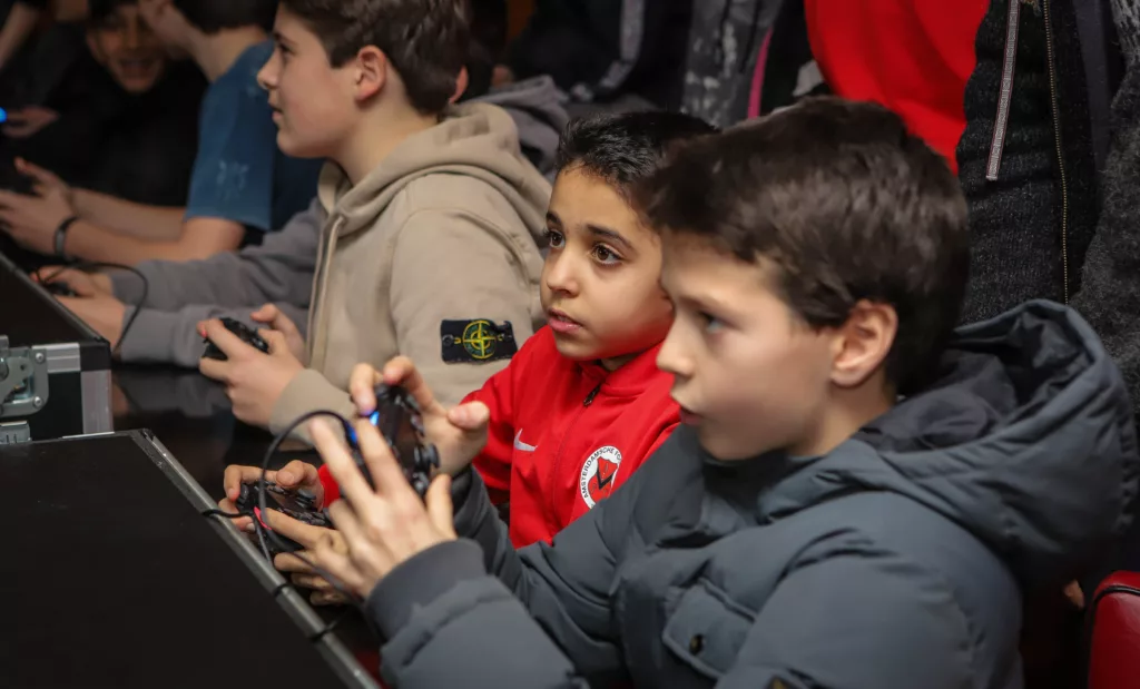 Twee jongens zijn aandachtig aan het gamen tijdens een FIFA toernooi